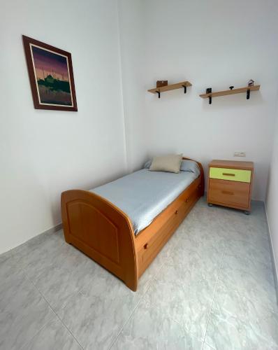 a small bedroom with a bed and a cabinet at Casa turística Lucena in Vilagarcia de Arousa