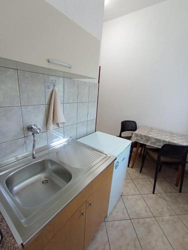 a kitchen with a sink and a table with a chair at Gjorgji Apartments 68a in Ohrid