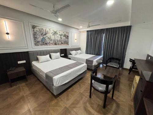 a hotel room with two beds and a desk at HOTEL SNR AURORa in Guntūr