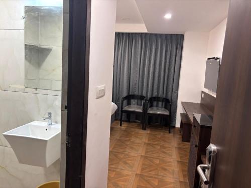 a bathroom with a sink and a toilet and a mirror at HOTEL SNR AURORa in Guntūr