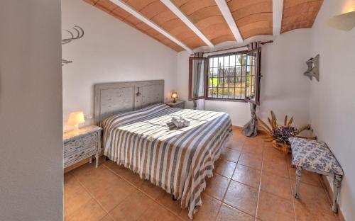 Un dormitorio con una cama y una mesa y una ventana. en Finca Hort De Sa Barrala, en Ses Covetes