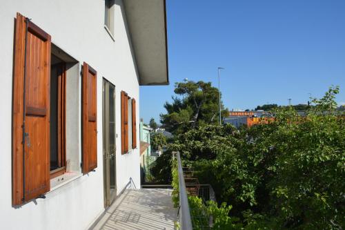 a balcony of a white building with wooden windows at Casa Argi in Camerano