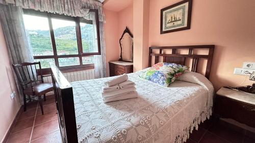 a bedroom with a bed with two towels on it at Casa Alpargateiro in Os Peares