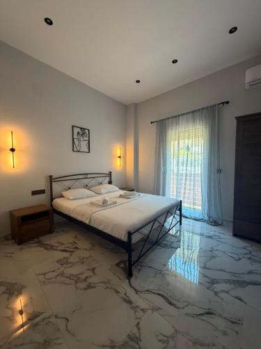 a bedroom with a bed with marble floors and a window at Vt Homes in Corfu
