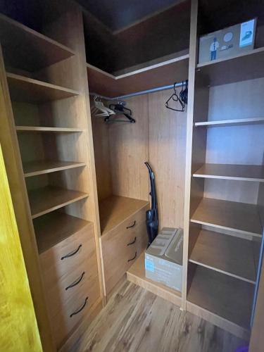 a closet with wooden shelves and a vacuum at Kosbor apartman in Igricetanya