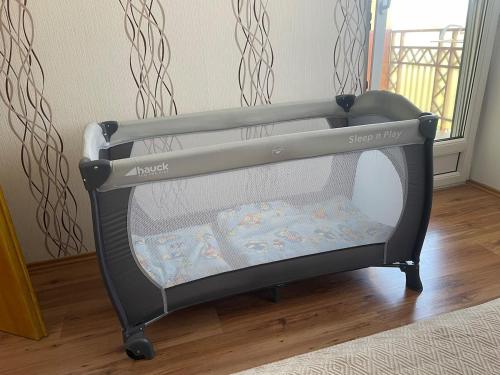 a black baby crib with a baby blanket in it at Kosbor apartman in Igricetanya