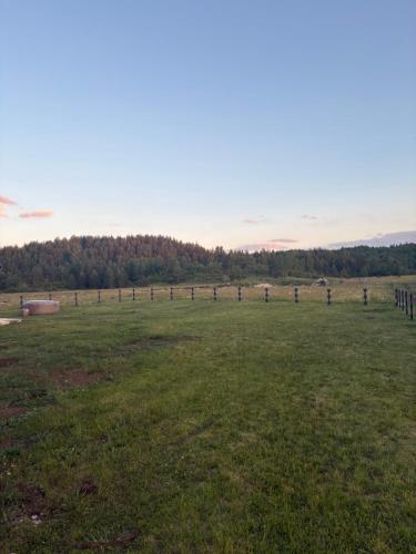 a field with a fence in the middle of it at Zabljak villa VAM in Žabljak