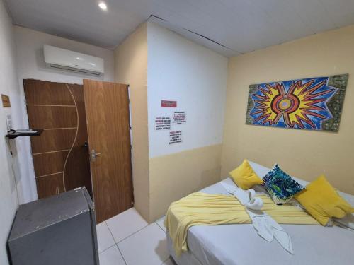 a bedroom with a bed with a painting on the wall at Hostel 4 Cantos in Olinda