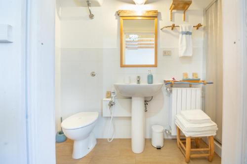 a white bathroom with a sink and a toilet at La collina sui trabocchi in Ortona