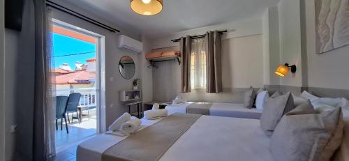 a white bedroom with a large bed and a balcony at House Kiriaki in Sarti