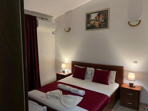 a bedroom with a bed with red and white pillows at Kasneci Apartments in Ulcinj