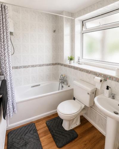 a bathroom with a toilet and a tub and a sink at Spacious 2 bedroom apartment near Wembley stadium with free parking in London