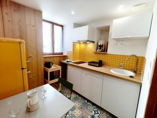 a small kitchen with a sink and a counter at Apparts'Hôtel Aspe in Bedous