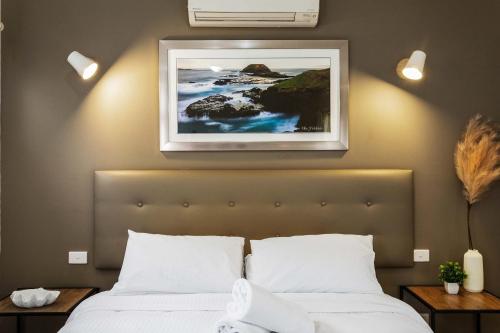 a bedroom with a bed and a picture on the wall at The Point Villa in Cowes