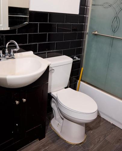 a bathroom with a toilet and a sink and a shower at SEVENeCOZY in Edgemere