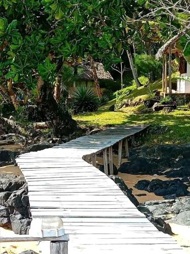 a wooden walkway in the middle of a park at Hôtel La Baleine in Sainte Marie