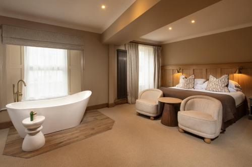 a bedroom with a bed and a bath tub and a bed at Budock Vean Hotel and Spa in Falmouth