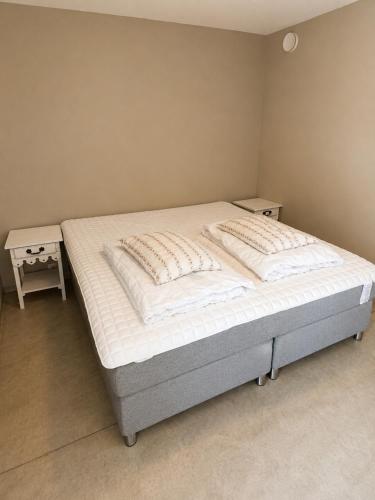 a bed in a room with two nightstands next to it at Olavsberget camping in Porsgrunn