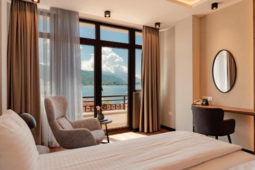 a hotel room with a bed and a large window at Hotel Aleksandrija in Ohrid