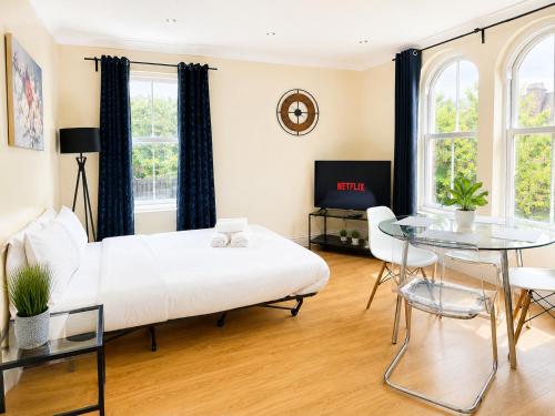 a bedroom with a bed and a table and chairs at Spacious flat in Streatham in London