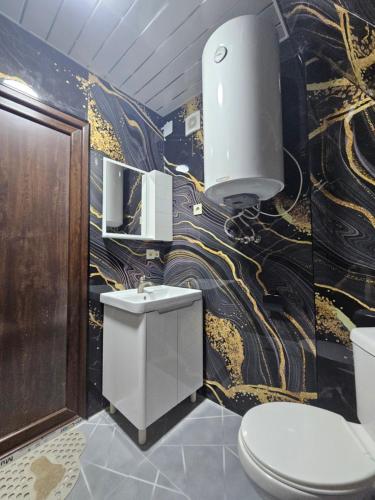 a bathroom with a toilet and a sink in it at Machaxela Skyline in Tsʼkhemlisi