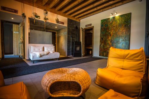 a living room with a yellow chair and a couch at Apparts'Hôtel Aspe in Bedous