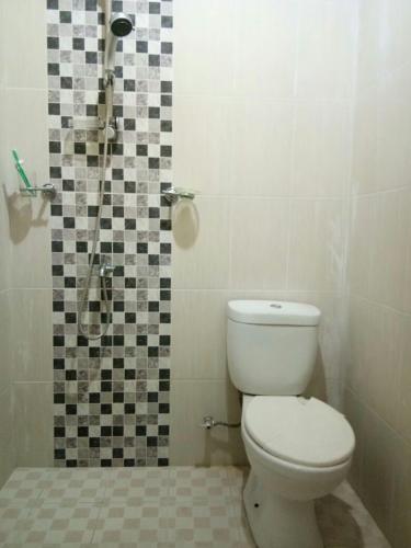 a bathroom with a toilet and a shower at Villa Batu Iggy in Batu