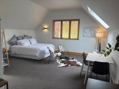 a bedroom with a bed and a table and chairs at Spacious 1 Bed apartment City centre in Palmerston North