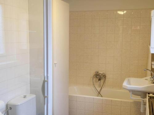 a bathroom with a tub and a toilet and a sink at Historic Cottage w Garden in Breskens