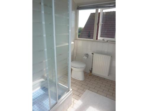 a bathroom with a toilet and a window at Bungalow in Breskens near Beach & Lighthouse in Breskens