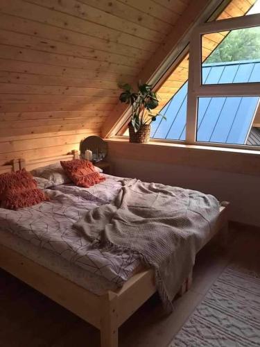 a large bed in a room with a window at Gorczańska Chatka in Osobie