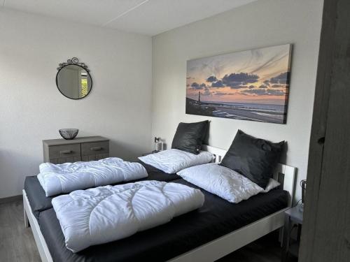 two beds sitting on top of a black couch at Bungalow in Breskens near Beach & Lighthouse in Breskens