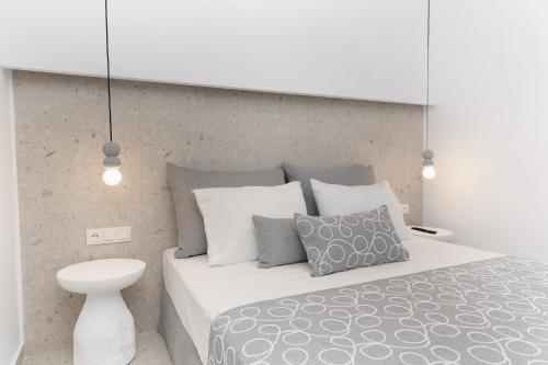 a bedroom with a white bed with gray and white pillows at Pyrgaki Hideout Beachfront Apartment in Agiassos