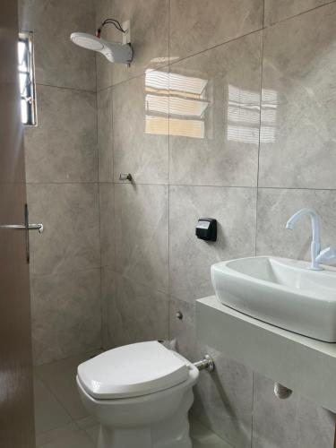 a bathroom with a toilet and a sink at Harmony House Hospedagem in Votuporanga