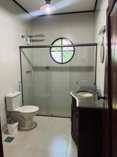 a bathroom with a shower and a toilet and a sink at Encanto da Serra casa 1 in Miguel Pereira