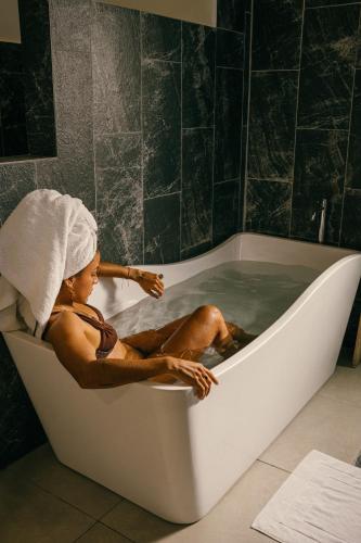 a man sitting in a bath tub with a towel on his head at Vikara in Olón