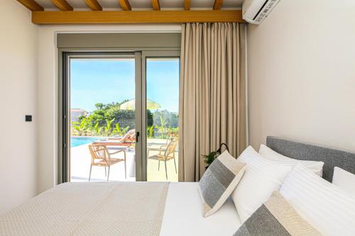 a bedroom with a bed and a view of a patio at Villa Emanouill Nopigia in Kissamos