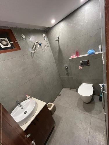 a bathroom with a white toilet and a sink at Cloud Eleven House in Kharar