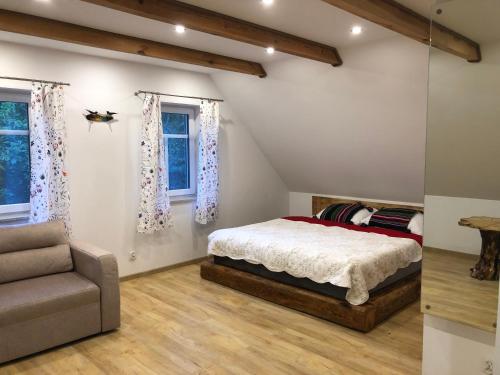 a bedroom with a bed and a couch and windows at ALVORADA Mościce Dolne nad Bugiem in Nowosiółki