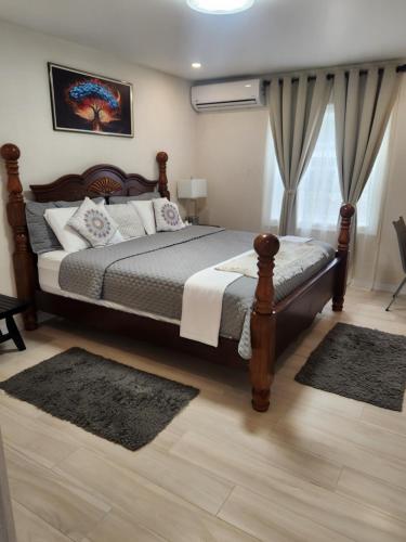 a bedroom with a large bed and a window at Jaden's Guest House in Saint Michael