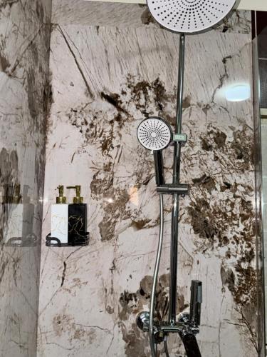 a shower in a bathroom with a stone wall at Gezim guest house in Shirokë