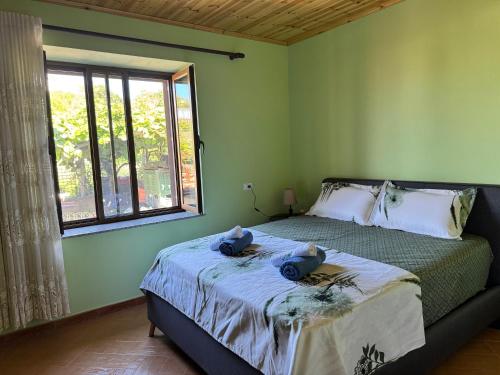 a bedroom with a bed with two stuffed animals on it at Gezim guest house in Shirokë