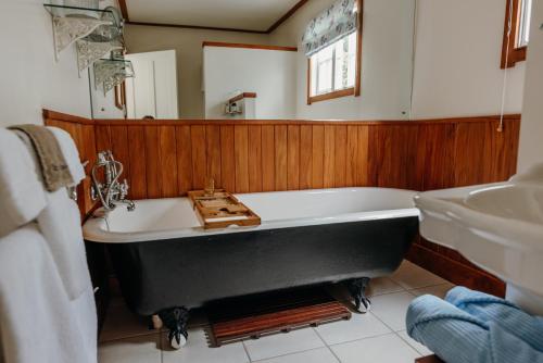 a bathroom with a black tub and a sink at Waipoua Lodge in Aranga