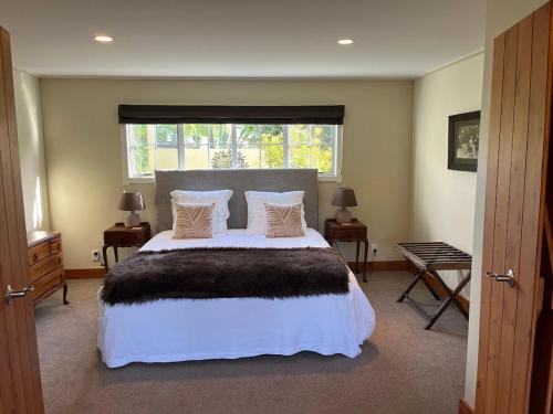 a bedroom with a large bed and a window at Waipoua Lodge in Aranga