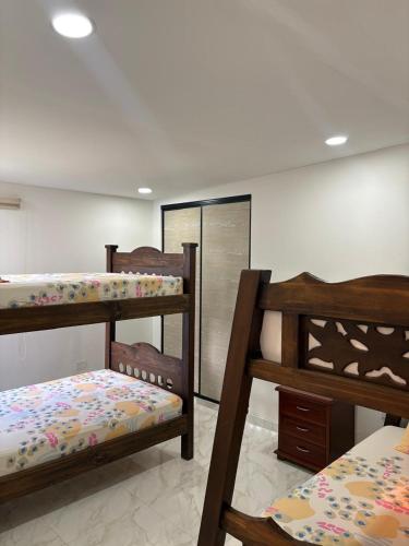 a bedroom with three bunk beds and a mirror at Finca San Barbara in Pavas