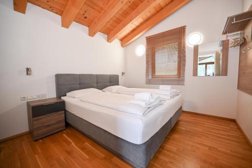 a bedroom with a large bed and a wooden floor at Ski Chalet Jim by All in One Apartments in Zell am See