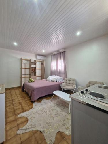 a bedroom with a bed and a kitchen with a stove at Le Cuprum in Le Robert