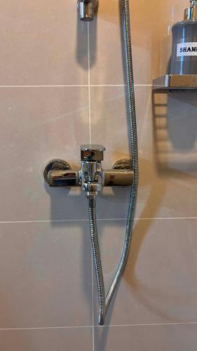a hose hooked up to a shower on a wall at Ciao Vacanza Staycation in San Fernando