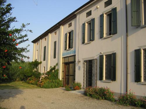 a white building with a door in a yard at Agriturismo Antica Golena in Guastalla