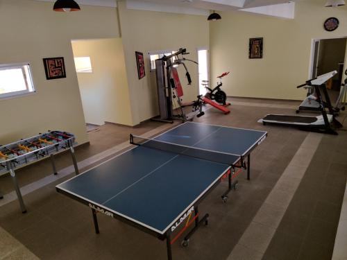 un gimnasio con mesa de ping pong en una habitación en Hotel Gladiador en San Bernardo